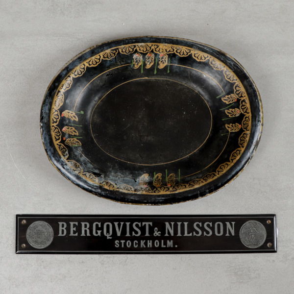 Skylt, trä "Bergqvist & Nilsson" samt bemålat plåtfat