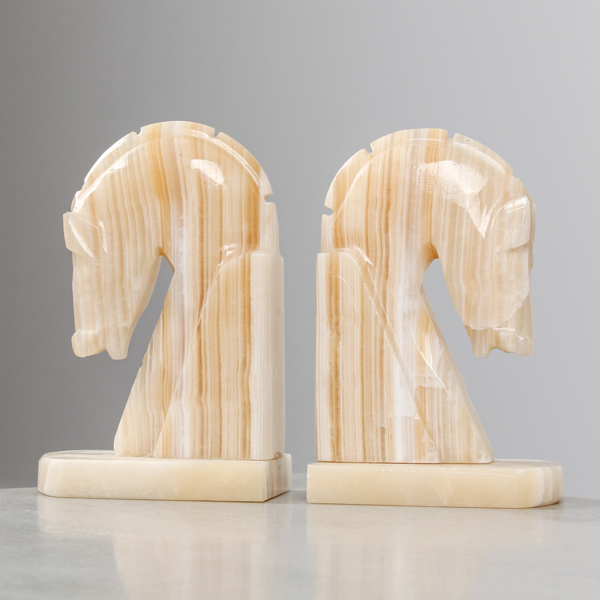 Bokstöd, i form av hästhuvuden, alabaster